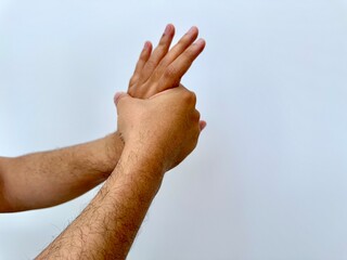 Man performs wrist extension using other hand. Pose suggests muscle tension, pain, spasm, or inflammation from injury or repetitive movement, commonly related to orthopedic or nerve issues.