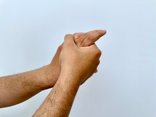 Man stretches wrist with one hand, showing sign of wrist pain, muscle strain, or tension. This posture may indicate discomfort, inflammation, or orthopedic issue from overuse or chronic disorder.