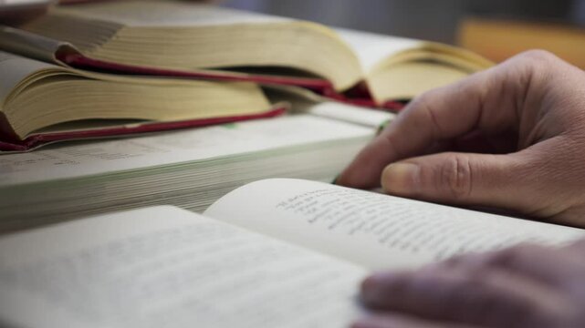 Researcher reads literature reference books in home library study CLOSE-UP