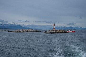 Sailing along the lighthouse on an islet in Beagle channel with lot of birds