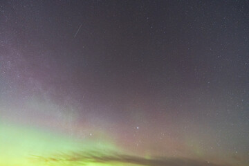 Natural texture background: Starry night sky with faint green and purple glow of Northern Lights...
