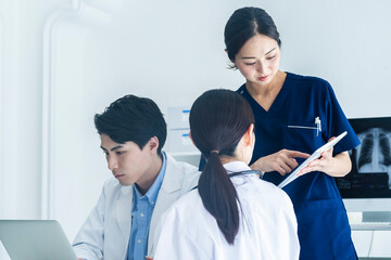 Doctors Reviewing Patient Charts with a Nurse Using a Tablet
A doctor points to a document while...