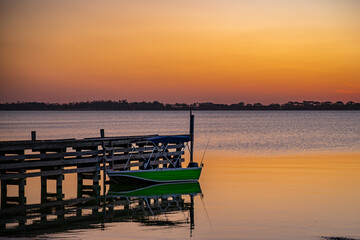 Fototapeta premium Sunset over the lake with a fishing boat moored at the pier, Lake Tooliorook, Victoria, Australia