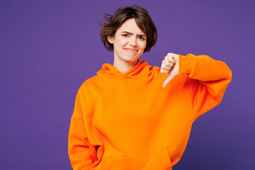 Young sad unhappy dissatisfied displeased Caucasian woman she wear orange hoody casual clothes...