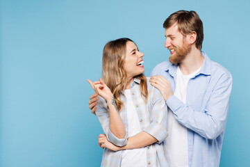 Young smiling couple two friends family man woman wear shirt casual clothes cuddle embrace look to each other together isolated on pastel plain blue cyan background studio portrait. Lifestyle concept.