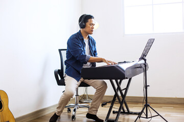 Full Length Of Mature Middle Aged Man Listening To The Tune Played On Electric Piano By Him © Gatot