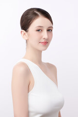 A beautiful young woman with clean, fresh skin against a white background. Skincare, facial treatment, cosmetology, beauty, and spa. An elegant portrait of an woman.