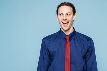 Young shocked surprised rich employee business man corporate lawyer wear classic formal shirt red tie work in office look aside on area isolated on plain pastel light blue background studio portrait.