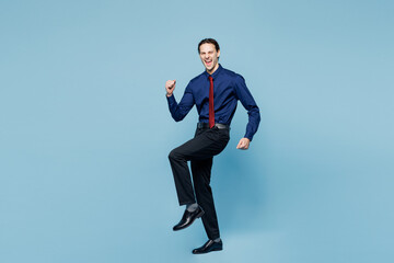 Full body young employee business man corporate lawyer wear classic formal shirt red tie work in office doing winner gesture celebrate clenching fists isolated on plain pastel blue background studio.