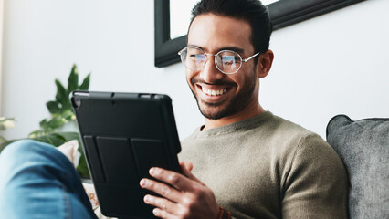 Home, laugh and man on sofa, tablet and glasses with connection, online comedy video and...