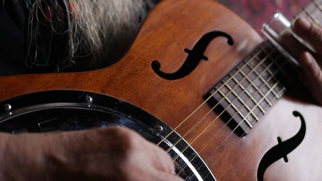 Male musician hand play Vintage Resonator acoustic dobro blues slide guitar.