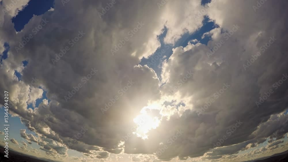 Poster dramatic fisheye view of sun breaking through clouds, creating a dynamic and expansive sky. ideal fo