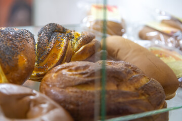 Freshly baked bread and sweet bun varieties displayed in a local bakery shop