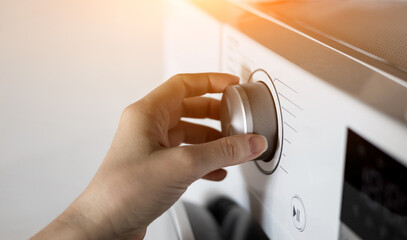  woman's hand sets the washing program