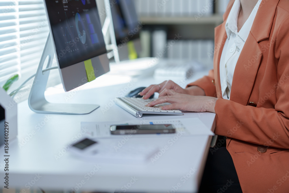 Poster businesswoman is typing on a computer keyboard while working with financial charts displayed on the 