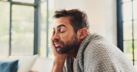Man, tired and sick with blanket on sofa, eyes closed or fever with fatigue, exhausted or headache...