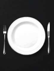 Empty plate, fork, knife on black