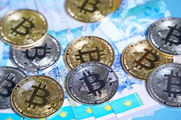 10,000 tenge banknotes and bitcoin coins are laid out on the table.
