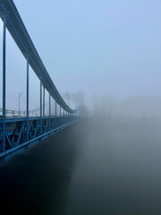 Obraz premium Car Bridge over the river in the city during fog. Grunwald Bridge, Wroclaw Poland