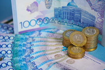 Tenge coins and banknotes are laid out on the table.