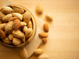 Raw organic whole almonds in a wooden bowl