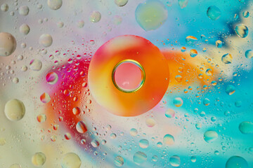 drops of oil on water with a colored background