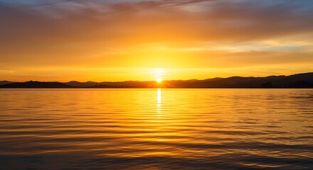 Obraz premium Sunset Over Calm Lake Water with Golden Reflection and Mountain Silhouette