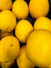 Pile of fresh canary melon displayed on market as food background