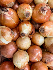 Pile of fresh onion displayed at groceries store as food background