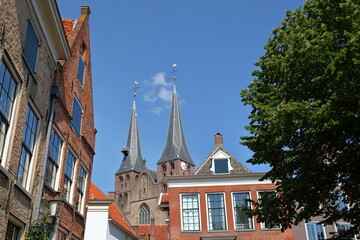 Traditional historic medieval houses, located in the neighborhood Bergkwartier of Deventer, Overijssel, Netherlands, with the two towers of Saint Nicholas church
