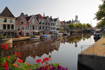 Reflections of traditional houses, barges and boats on the little canal (klein Diep) in Dokkum, Friesland, Netherlands, with the Oud Stadhuis (Old Town Hall, built in 1610) in the background