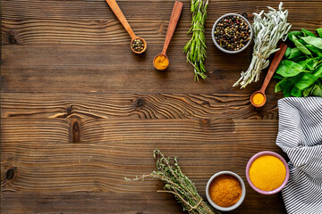 Frame of green herbs and spices in bowls for cooking, top view