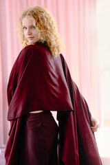 Naklejka premium woman with white curly hair, in burgundy. Exquisite accessories and burgundy outfit emphasize the elegance and style of the model.