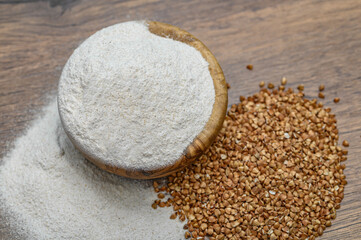 Mąka z kaszy gryczanej w drewnianej miseczce lozaca obić całych ziaren kaszy 