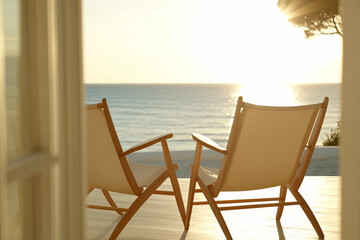 Serenity by the Beach at Sunset with Minimalist Modern Chairs Overlooking Calm Ocean Waves