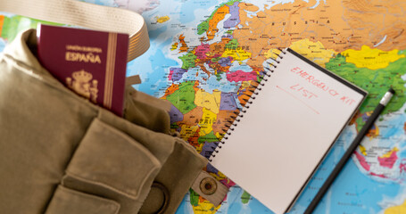 Essential travel preparedness concept with emergency kit list, passport, and Europe map...