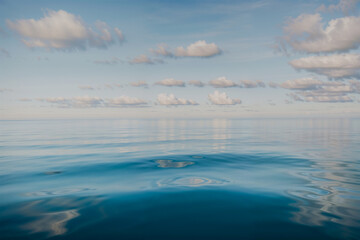 Obraz premium Tranquil ocean view with rocks under a clear blue sky at dusk