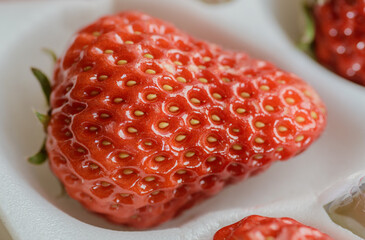 Natural looking fresh red strawberry in package.