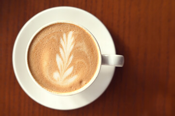 Coffee Latte with milk foam on brown table at cafe