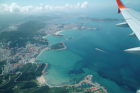 Aerial view of coastal cityscape with turquoise water and airplane wing