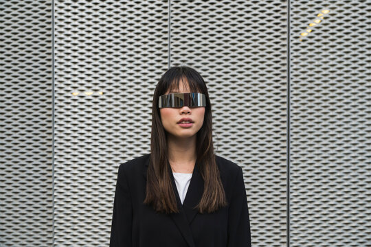 Asian businessoman wearing cyberglasses in a futuristic suit