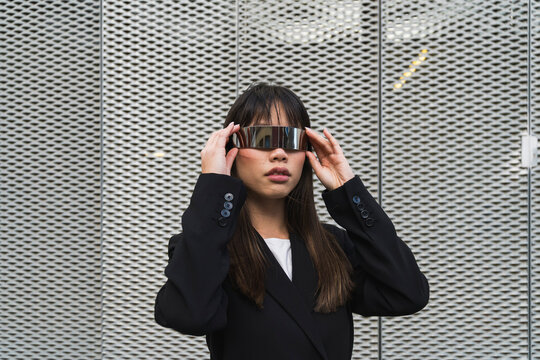 Asian businessoman wearing cyberglasses in a futuristic suit