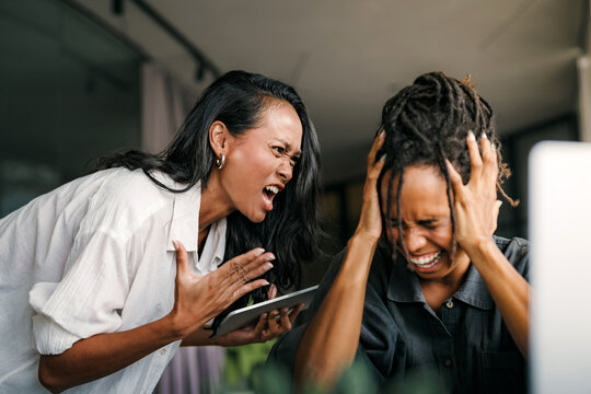 Workplace aggression, stressful work environment. Angry boss shouting at the worker in the office - Powered by Adobe