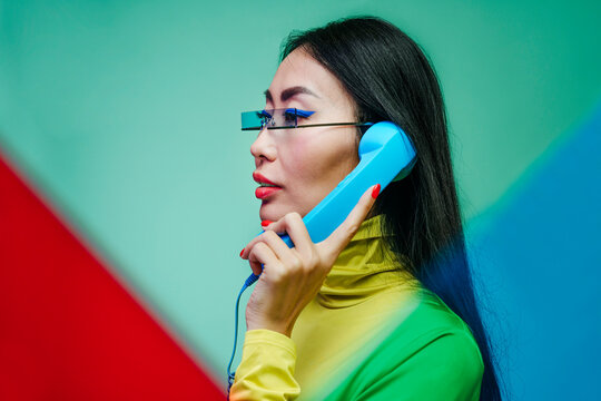 Stylish woman with glasses holding a retro phone