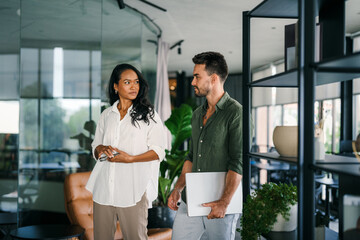 Group of young multi-ethnic startup business team collaborating on project in modern office