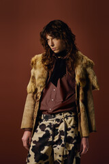 Stylish young man showcases trendy fashion on a warm toned backdrop