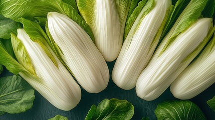 Fototapeta premium Fresh Napa cabbage leaves arranged on a dark surface.