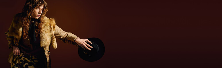 Stylish young man showcasing unique fashion sense with a dramatic flair indoors