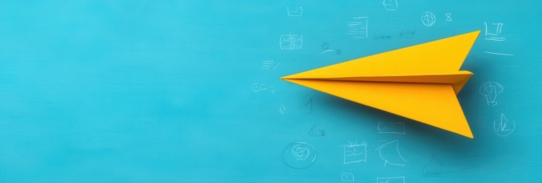 Yellow Paper Airplane on Turquoise Backdrop with White Accents in Flat Lay Style