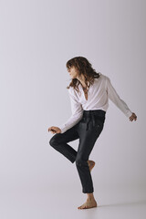 Stylish young man strikes a confident pose against a minimal backdrop in a modern studio